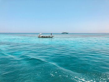 Sailboat sailing in sea against clear sky