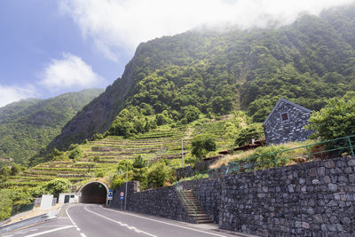 Road by mountain against sky