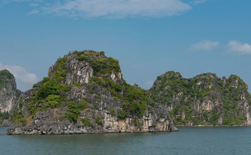 Rock formations by sea against sky