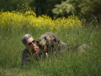 Mature woman lying with dog at park