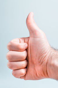 Close-up of person hand against white background