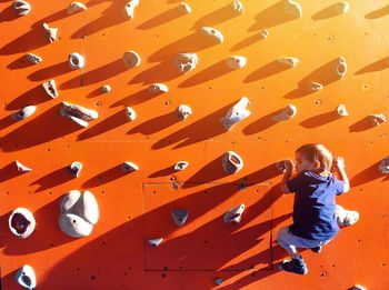 Boy climbing up wall