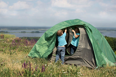 Sibling setting tent on field