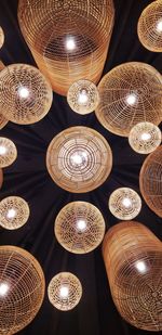 Low angle view of illuminated pendant lights hanging from ceiling