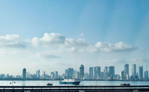 City buildings by sea against sky