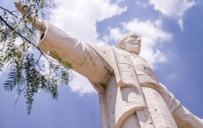 Low angle view of statue against trees and sky