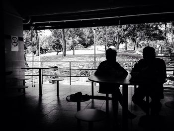 Rear view of silhouette people sitting on chair