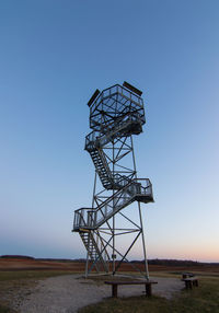 Low angle view of towerl on field against clear sky