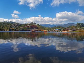 Scenic view of lake by buildings against sky