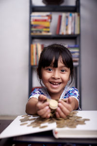 Portrait of smiling girl on table