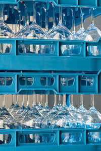 Blue plastic boxes with shiny wineglasses for restaurant standing upside-down and reflecting light