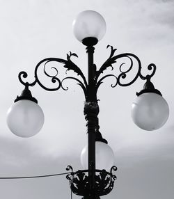 Low angle view of illuminated lanterns hanging against sky