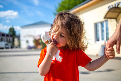 Cute girl eating ice cream outdoors