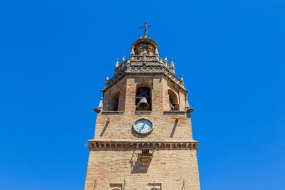 Low angle view of clock tower against blue sky