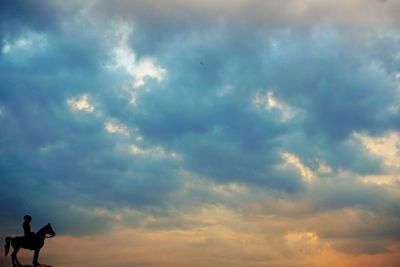 Low angle view of silhouette birds flying against sky