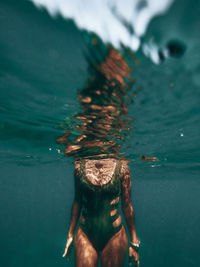 Midsection of woman swimming in sea