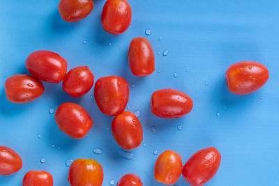 Close-up of wet cherries against blue background