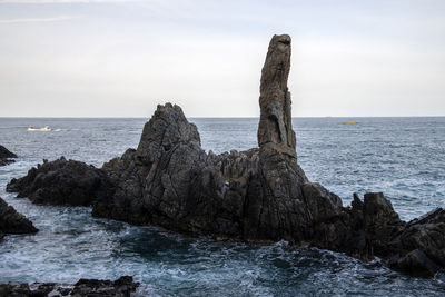 Scenic view of rocks in sea against sky