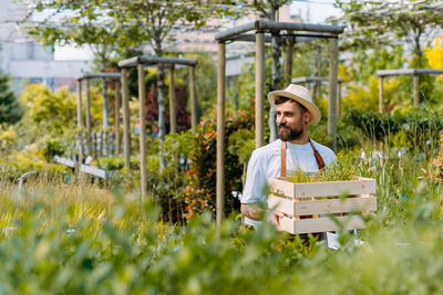 Portrait of young woman standing in greenhouse