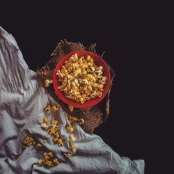 Low angle view of person holding bowl against black background