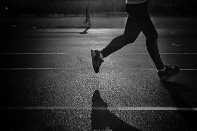 Low section of woman walking on road