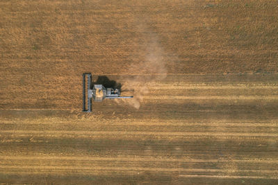 New black harvester on the wheat field from the top view. harvest time.