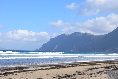 Scenic view of sea and mountains against sky