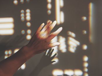 Close-up of hand touching illuminated lights