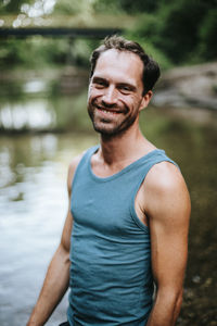 Portrait of young man standing in river