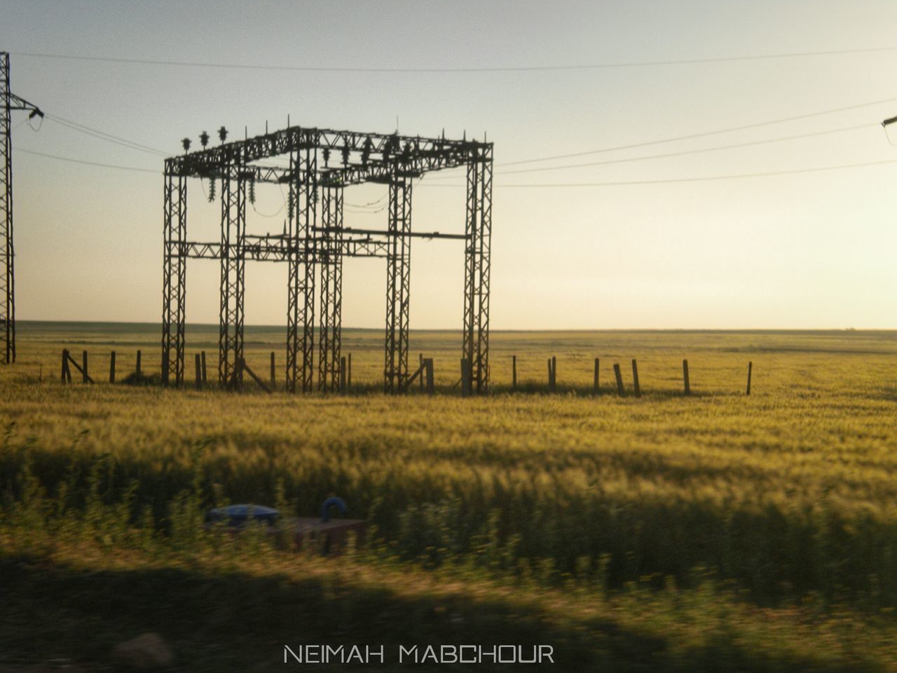 VIEW OF ELECTRICITY PYLONS ON FIELD