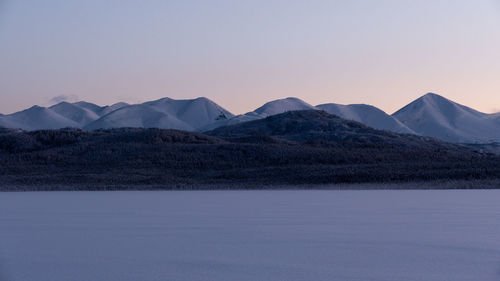 Scenic view of snowcapped mountains against sky during sunset