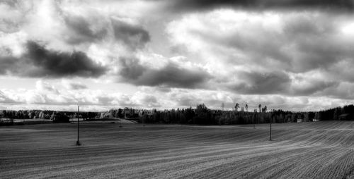 Scenic view of field against cloudy sky