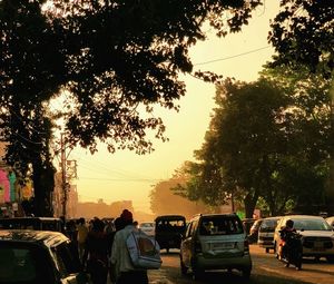 People on street against sky during sunset