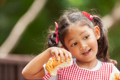 Close-up of cute girl holding bread