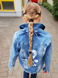 Rear view of woman standing against blue wall