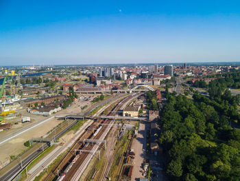 High angle view of city buildings against clear blue sky