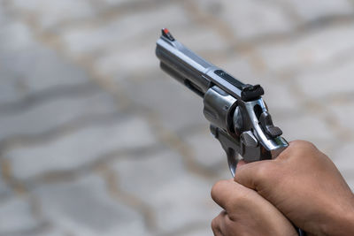Close-up of hands holding gun