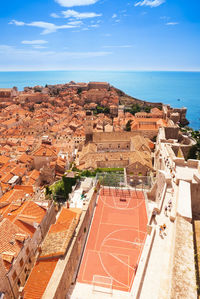 High angle view of townscape by sea against sky