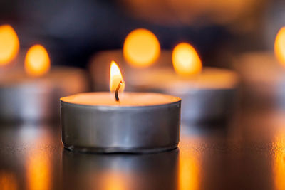 Close-up of illuminated tea light candles on table