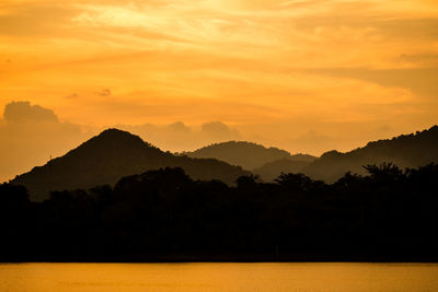 Scenic view of silhouette mountains against romantic sky at sunset