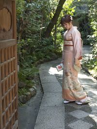 Rear view of woman standing against trees