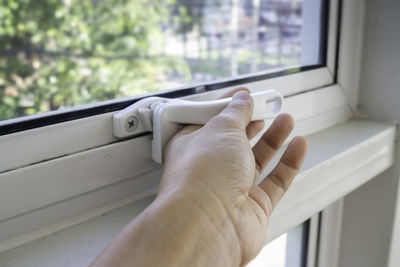 Close-up of man hand holding window