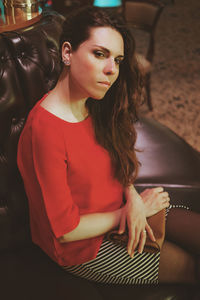 Portrait of woman sitting on sofa at restaurant