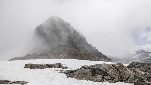 Scenic view of rocks in snow against sky