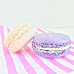 Close-up of macaroons on striped table against wall