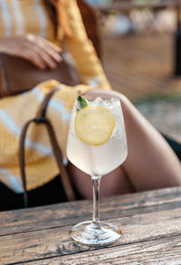 Close-up photo of refreshing lemonade in wine glass on table in beach bar