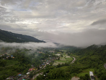 Aerial view of a village in the lush green rain cloud cover tropical rain forest mountain