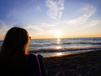 A woman takes in a stunning sunset over lake huron