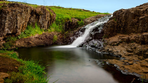 Scenic view of waterfall against rocks
