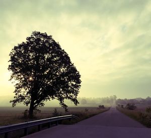 Country road against cloudy sky